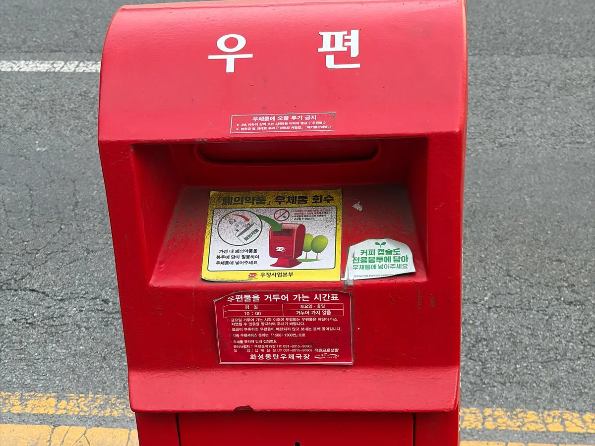 도로변에 세워진 빨간색 우체통의 투입구 부분