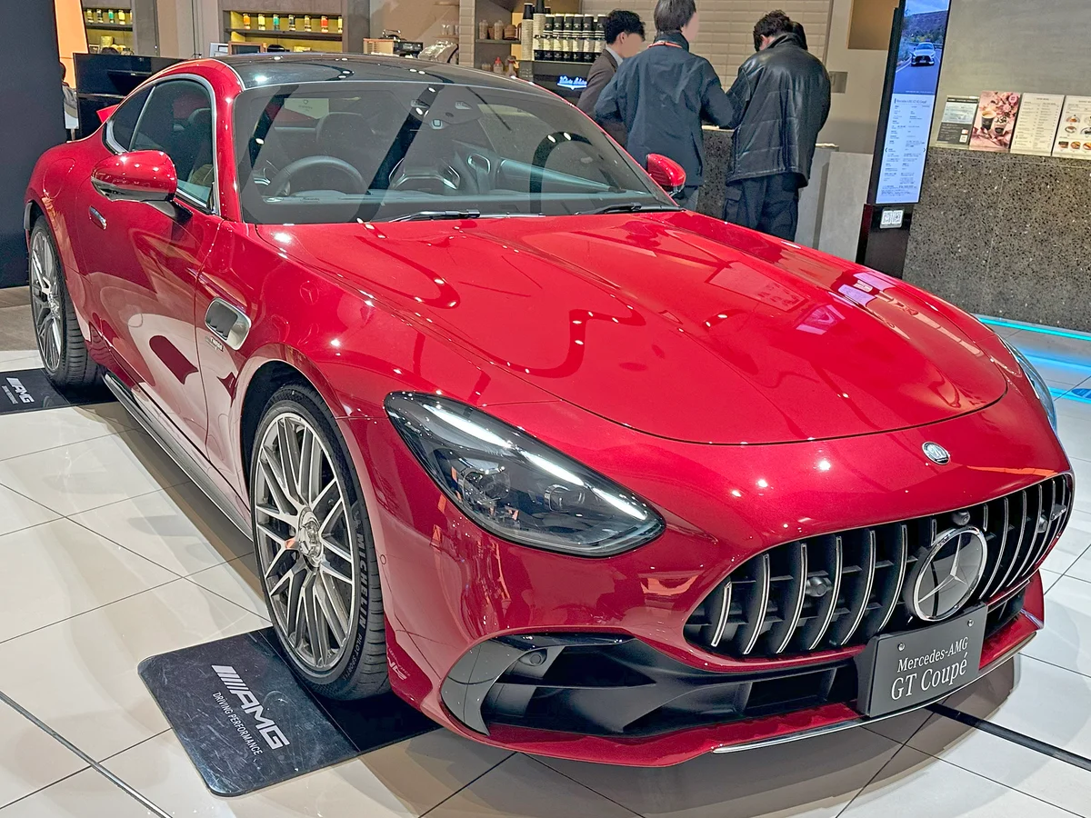전시장에 놓인 붉은색 메르세데스-AMG GT 43 쿠페의 전면 비스듬한 모습