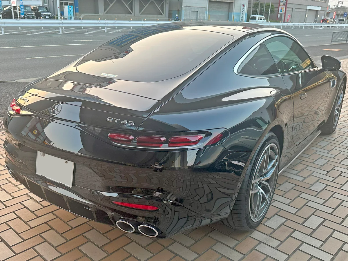 검은색 메르세데스-AMG GT 43 쿠페의 후측면, 테일램프와 듀얼 배기구가 보인다