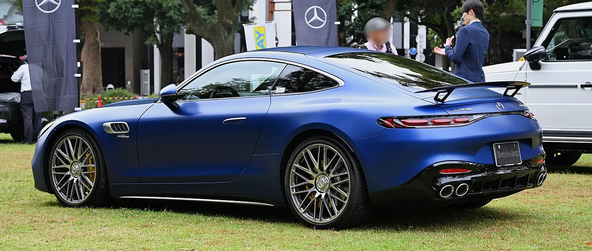 파란색 메르세데스-AMG GT 43 쿠페의 후측면, 올라간 리어 스포일러와 쿼드 배기구가 보인다