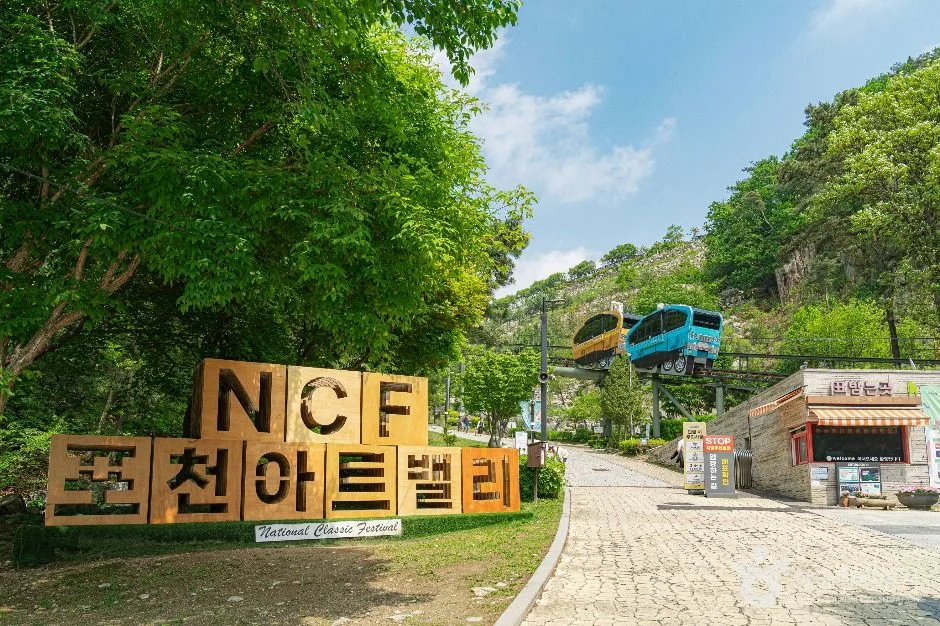 'NCF 포천아트밸리' 나무 입간판과 보행로, 뒤쪽 모노레일
