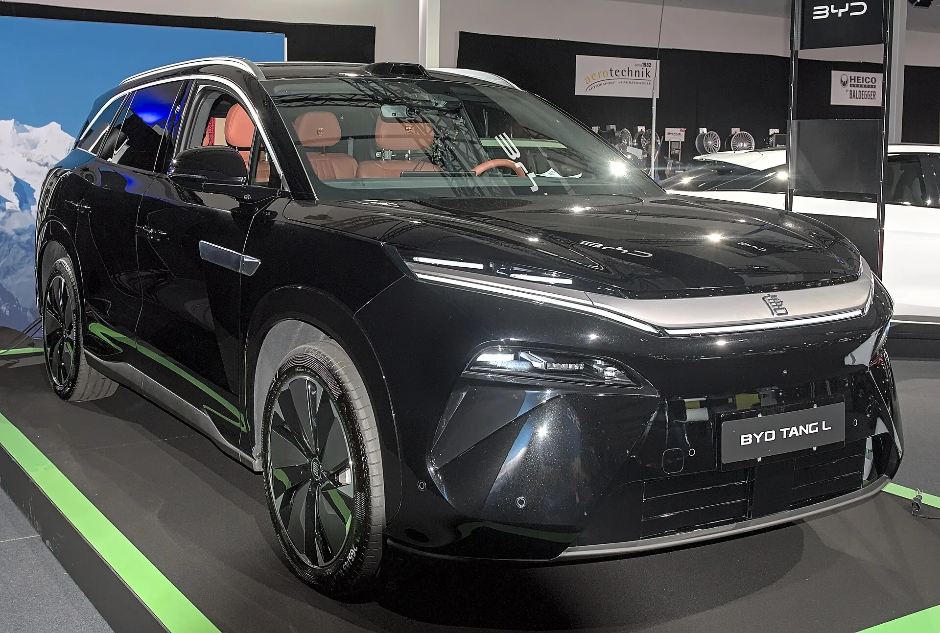 검은색 BYD 탕 L 전측면 사진, 실내의 주황색 시트가 창으로 보인다