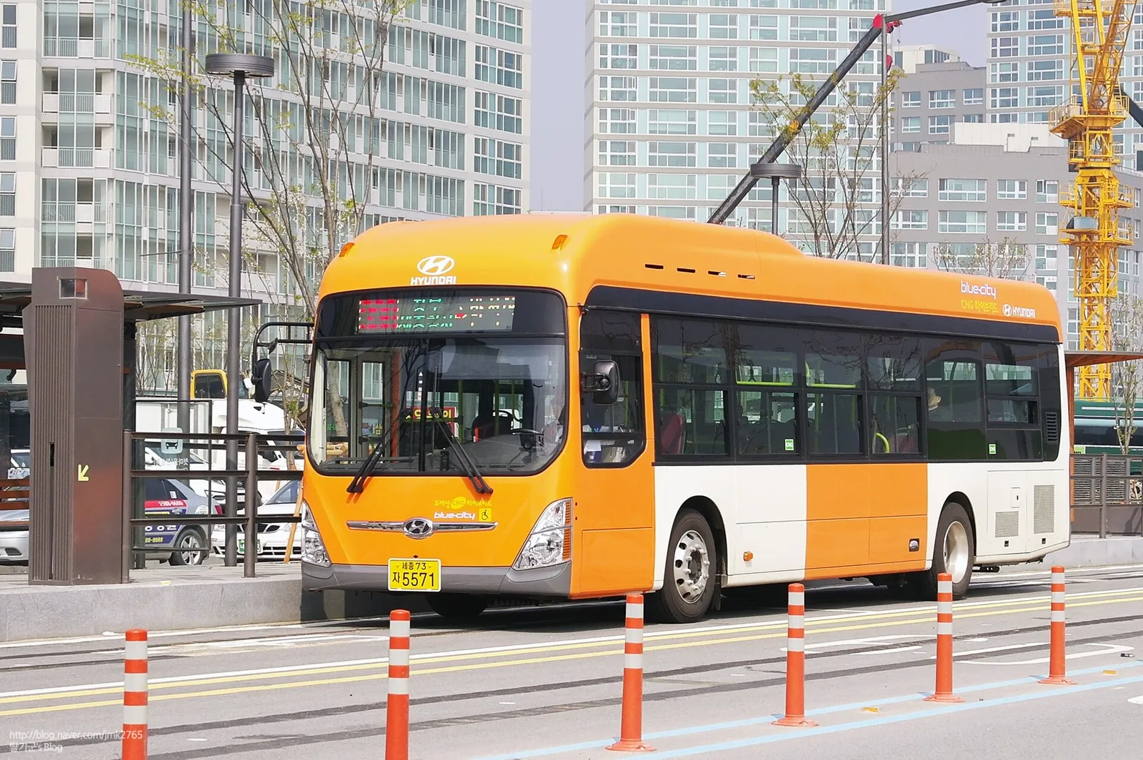 주황색과 흰색 현대 블루시티 BRT 버스가 전용차로를 달리는 모습