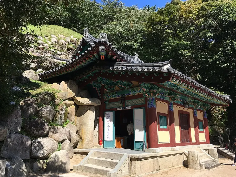 바위 옆에 놓인 단청 전각과 입구 계단