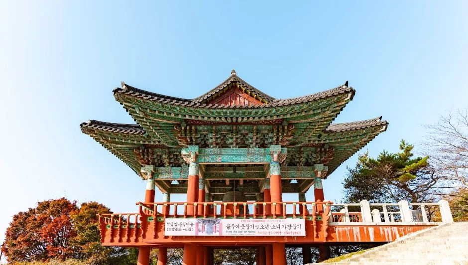 붉은 기둥과 녹색 단청의 2층 범종각과 맑은 하늘