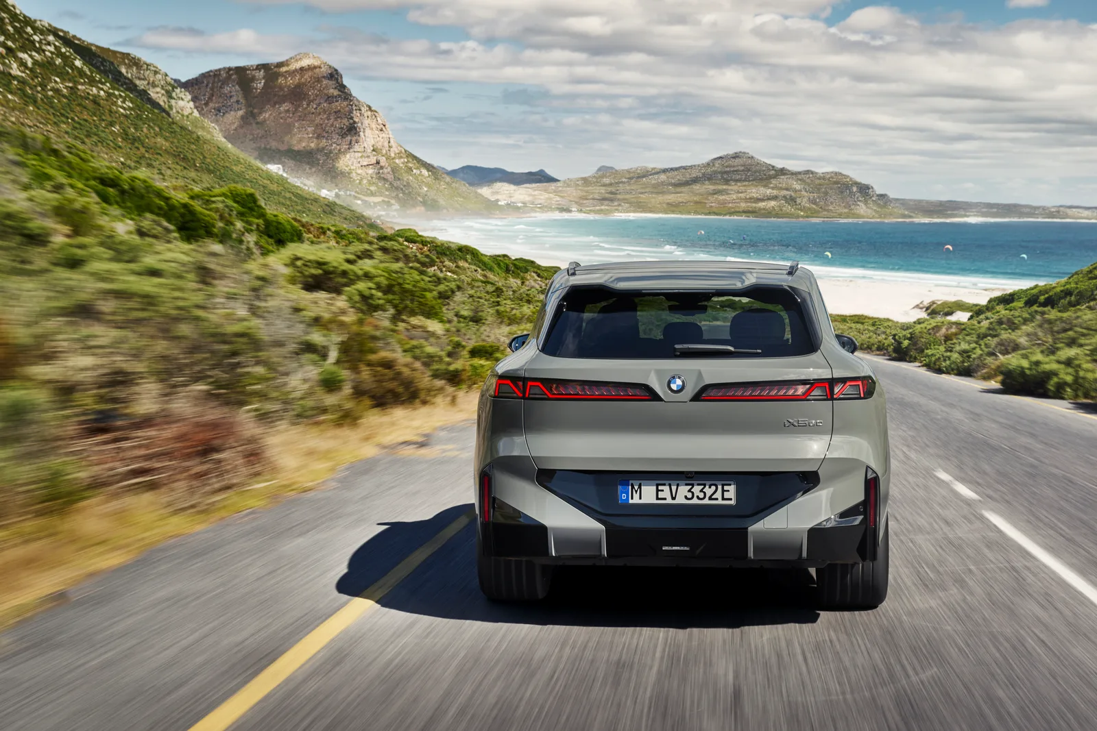 신형 BMW X5의 후면 주행 모습, 얇고 넓게 이어지는 테일램프와 완만해진 루프라인이 보인다