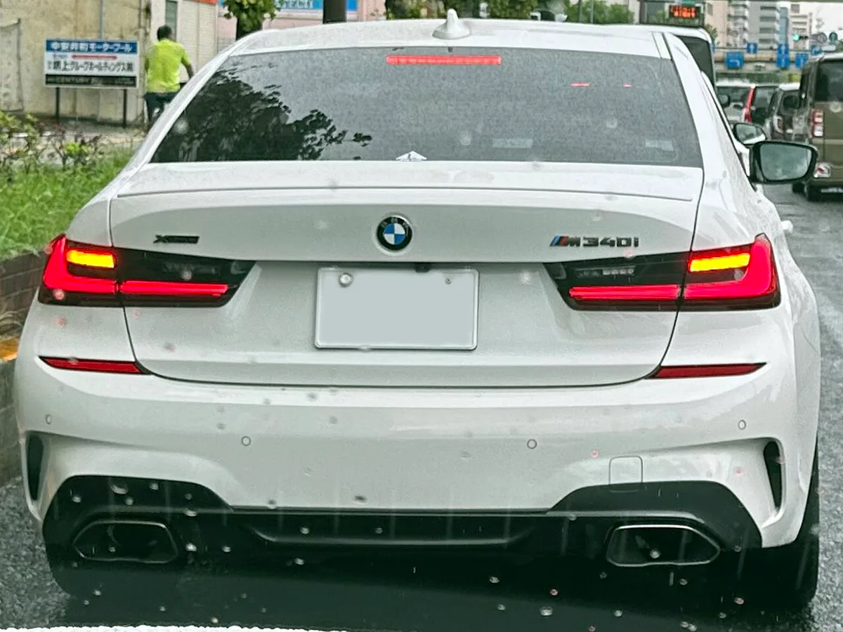 흰색 현행 BMW M340i xDrive의 뒷모습, 트렁크에 M340i 배지와 듀얼 배기구가 보인다