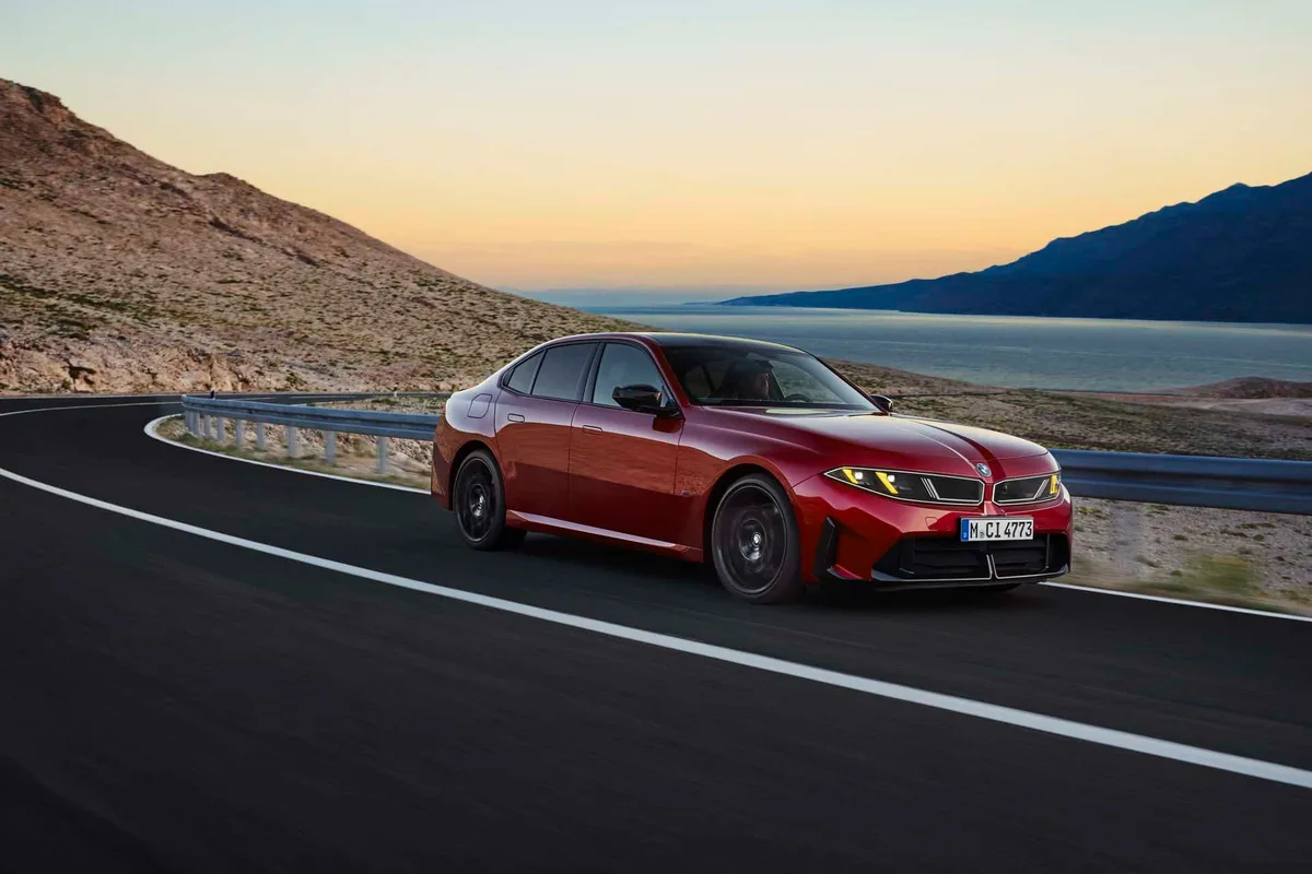 석양 무렵 해안 도로를 달리는 붉은색 BMW M350 xDrive의 앞모습