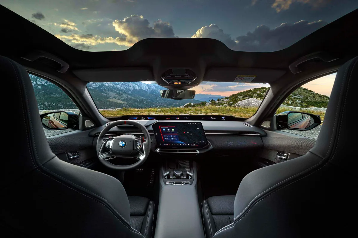 검은색 시트와 가로로 긴 대시보드, 대형 중앙 디스플레이가 있는 BMW M350 xDrive의 운전석 실내
