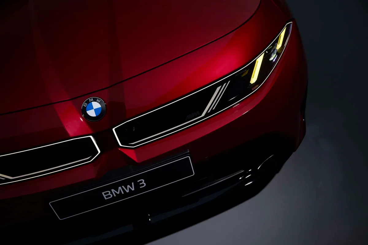 붉은 차체 앞 펜더와 헤드램프 위로 노란 주간주행등이 켜진 BMW M350 xDrive 앞부분 근접 사진