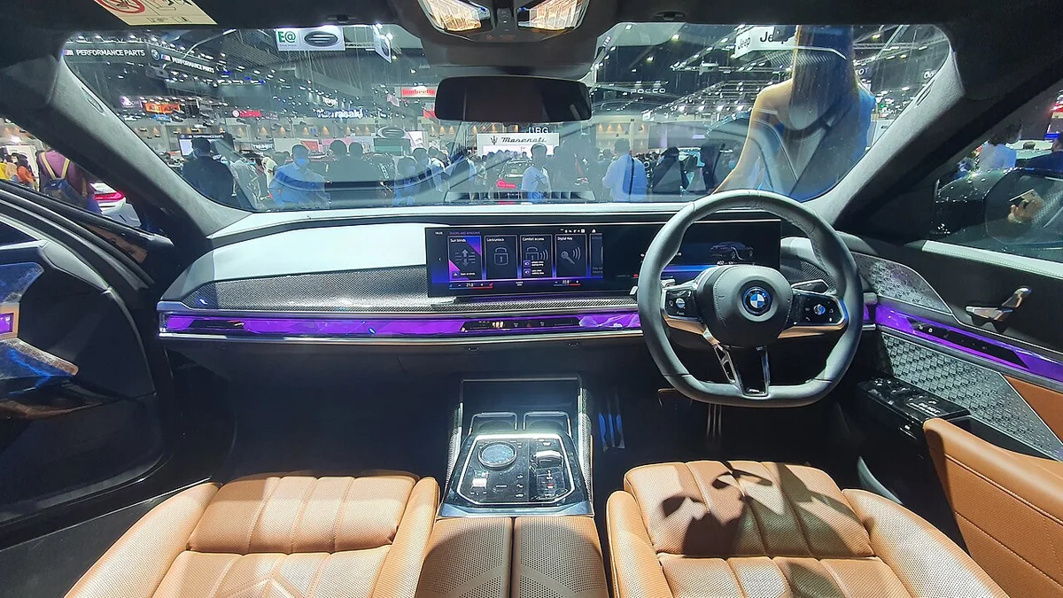 BMW 7시리즈 G70의 실내, 곡면 디스플레이와 갈색 가죽 시트가 보인다