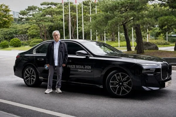 BMW 7시리즈 전측면, 블랙 색상, 프리즈 서울 2026 오피셜 파트너 문구가 새겨진 야외 촬영
