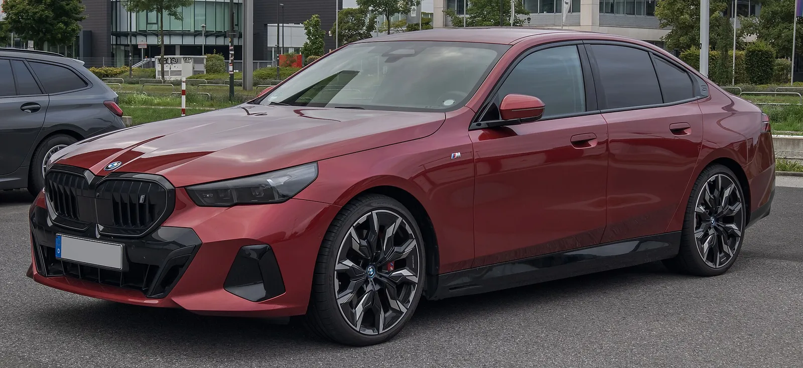 붉은색 BMW i5(G60) M 스포츠 프로 전면 3/4 모습, 블랙 키드니 그릴과 대형 휠이 보인다