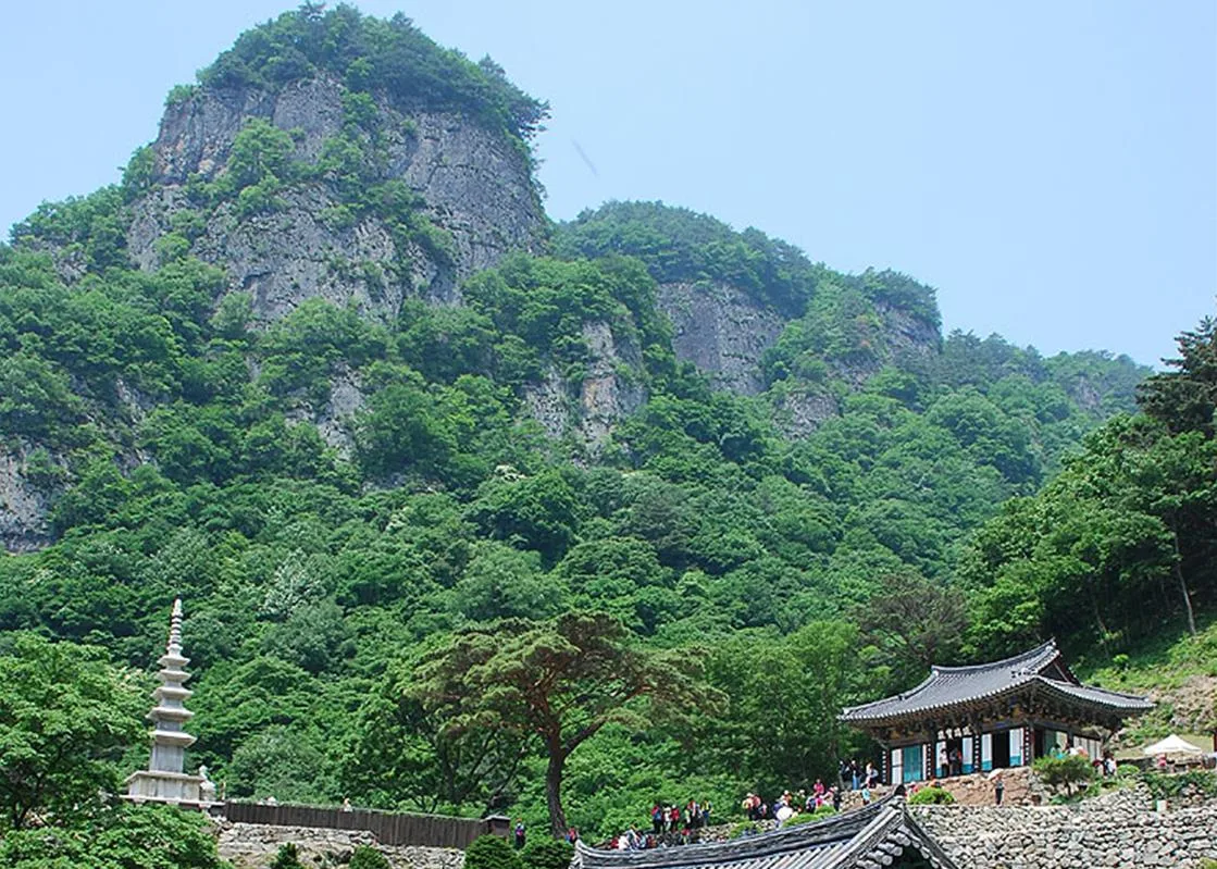 기암절벽을 배경으로 자리한 청량사 유리보전 기와지붕 건물과 앞마당의 오층석탑