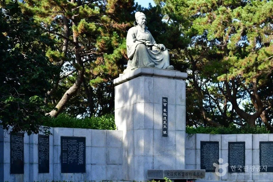 동백섬 소나무 아래 기단 위에 세워진 인물 동상과 비문