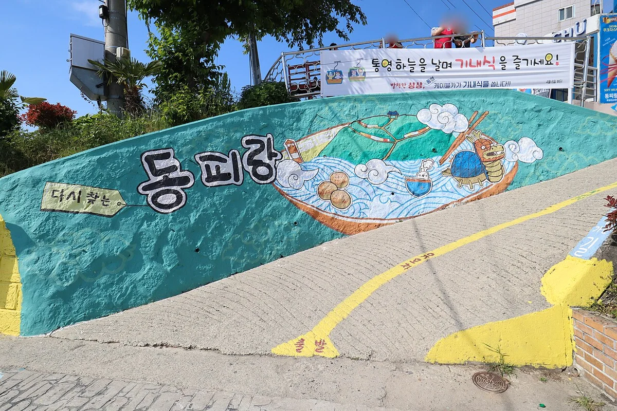 언덕길 옆 옹벽에 '동피랑' 글자와 배·바다 그림이 그려진 벽화