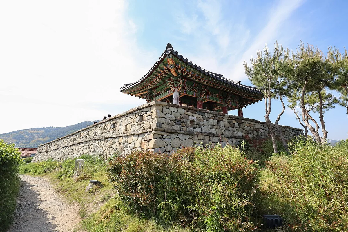 푸른 하늘 아래 성벽 위에 올려진 동포루 전각과 소나무