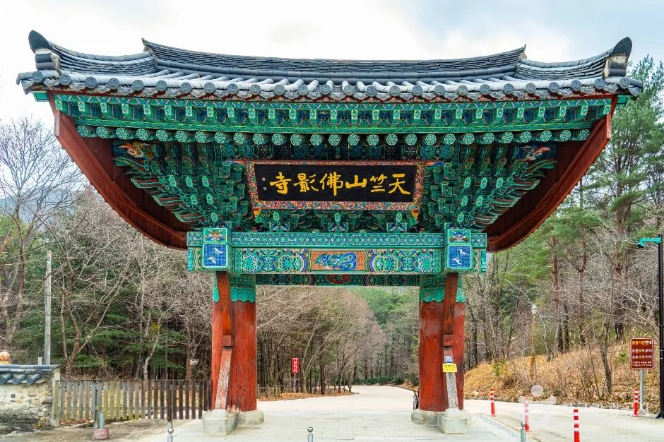 "天竺山 佛影寺" 현판이 걸린 붉은 기둥의 일주문과 그 앞 길