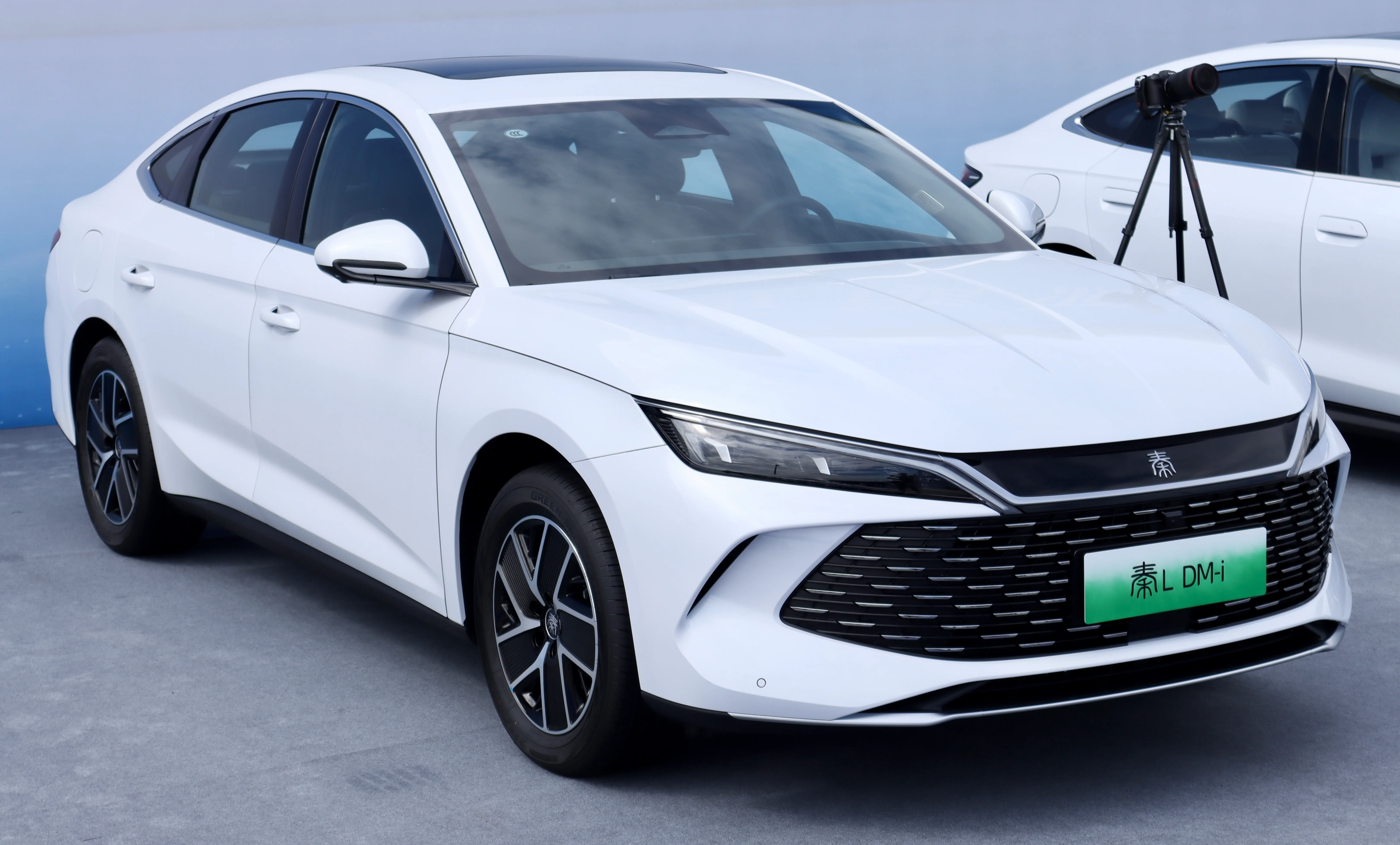 BYD 친 L DM-i 전측면, 화이트 색상, '秦L DM-i' 번호판이 부착된 모터쇼 전시 모습