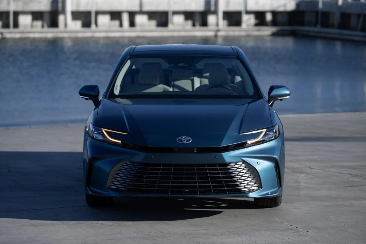 물가를 배경으로 정면에서 본 파란색 2027 토요타 캠리 XLE AWD