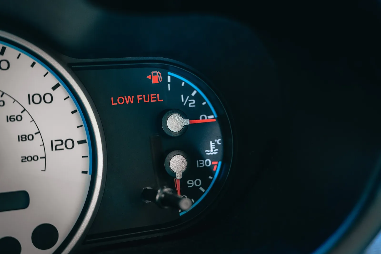 연료 게이지가 바닥에 가깝고 LOW FUEL 경고가 빨갛게 들어온 계기판