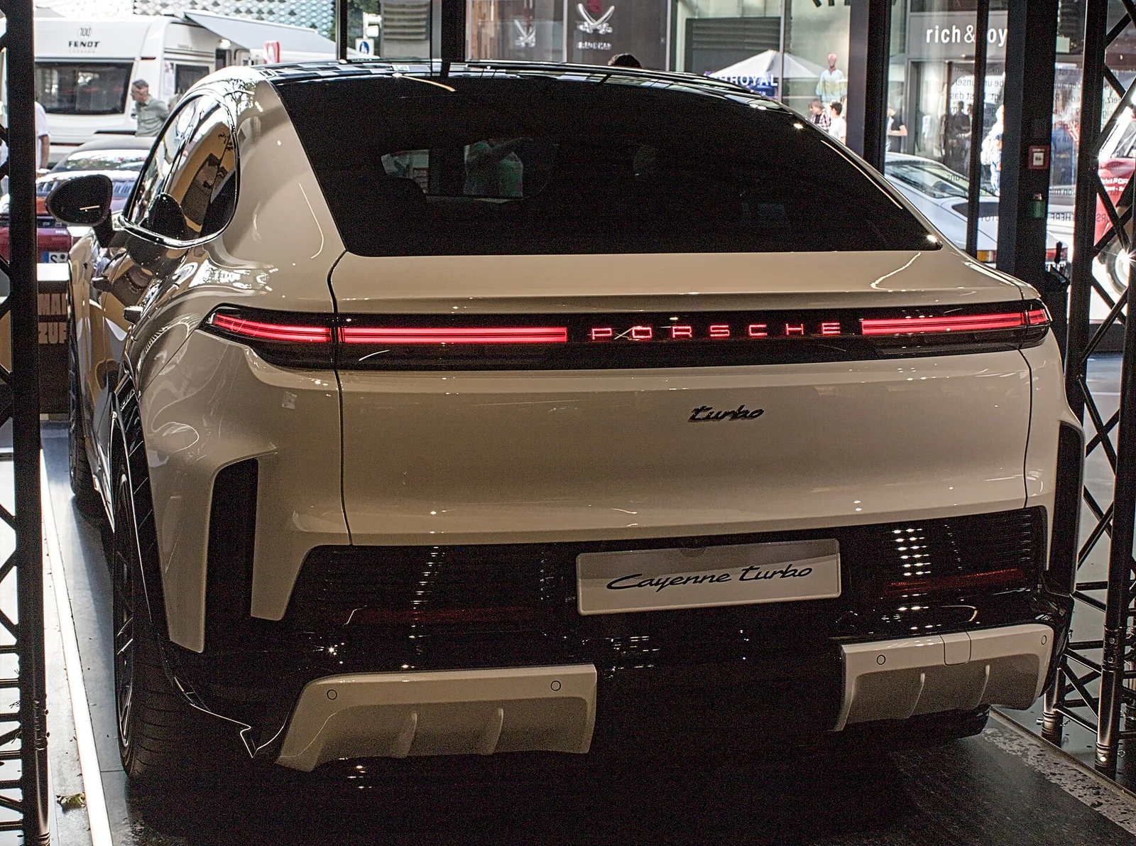 카이엔 터보 쿠페 일렉트릭 후면, 좌우로 이어진 라이트바와 PORSCHE 레터링, 경사진 테일게이트가 보인다