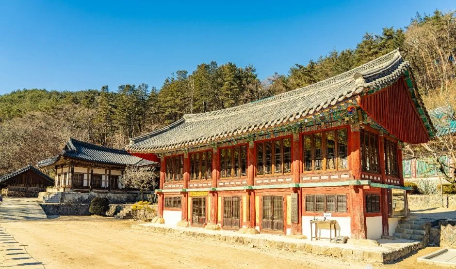 붉은 기둥과 흰 벽의 큰 한옥 건물이 보이는 청암사 마당