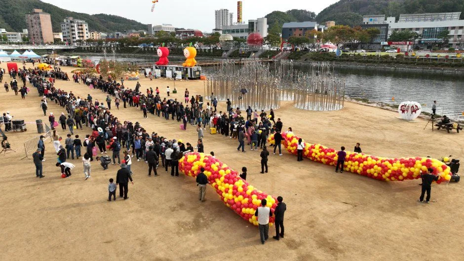 풍선으로 만든 붉은색·노란색 꽃줄이 모래밭에 길게 놓인 모습