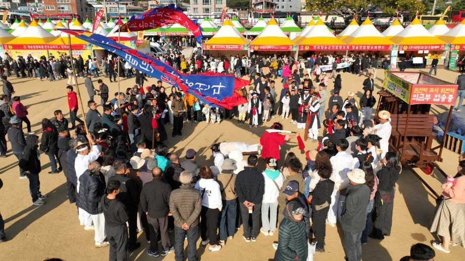 깃발 아래 모여 공연을 보는 많은 관람객