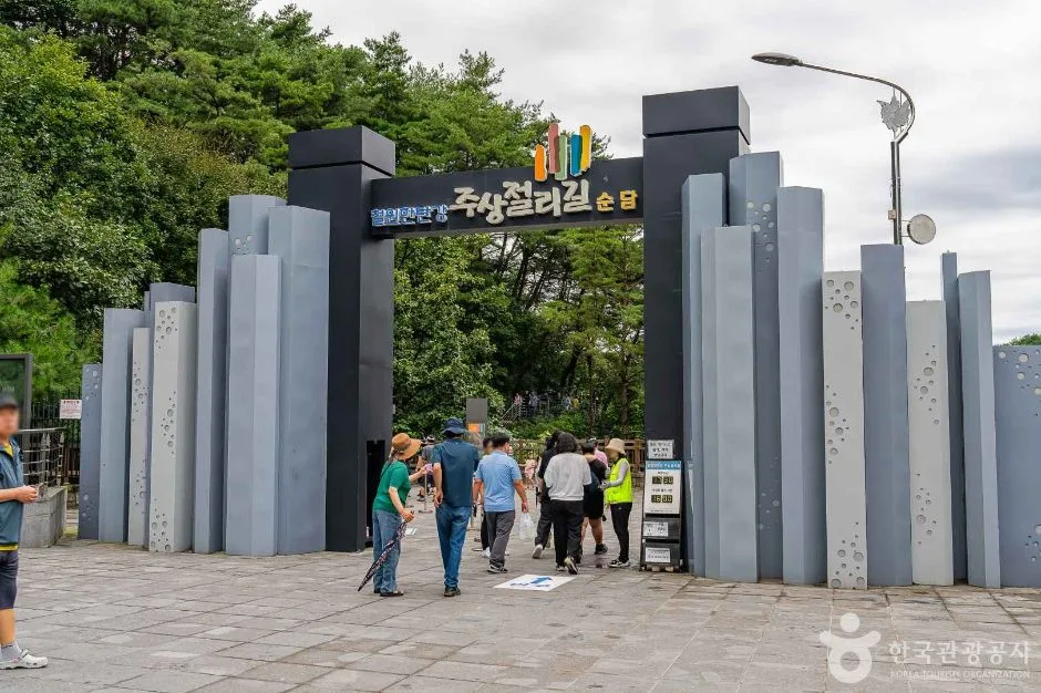 돌기둥 모양 조형물이 서 있는 한탄강 주상절리길 입구와 매표소 앞에 선 방문객들