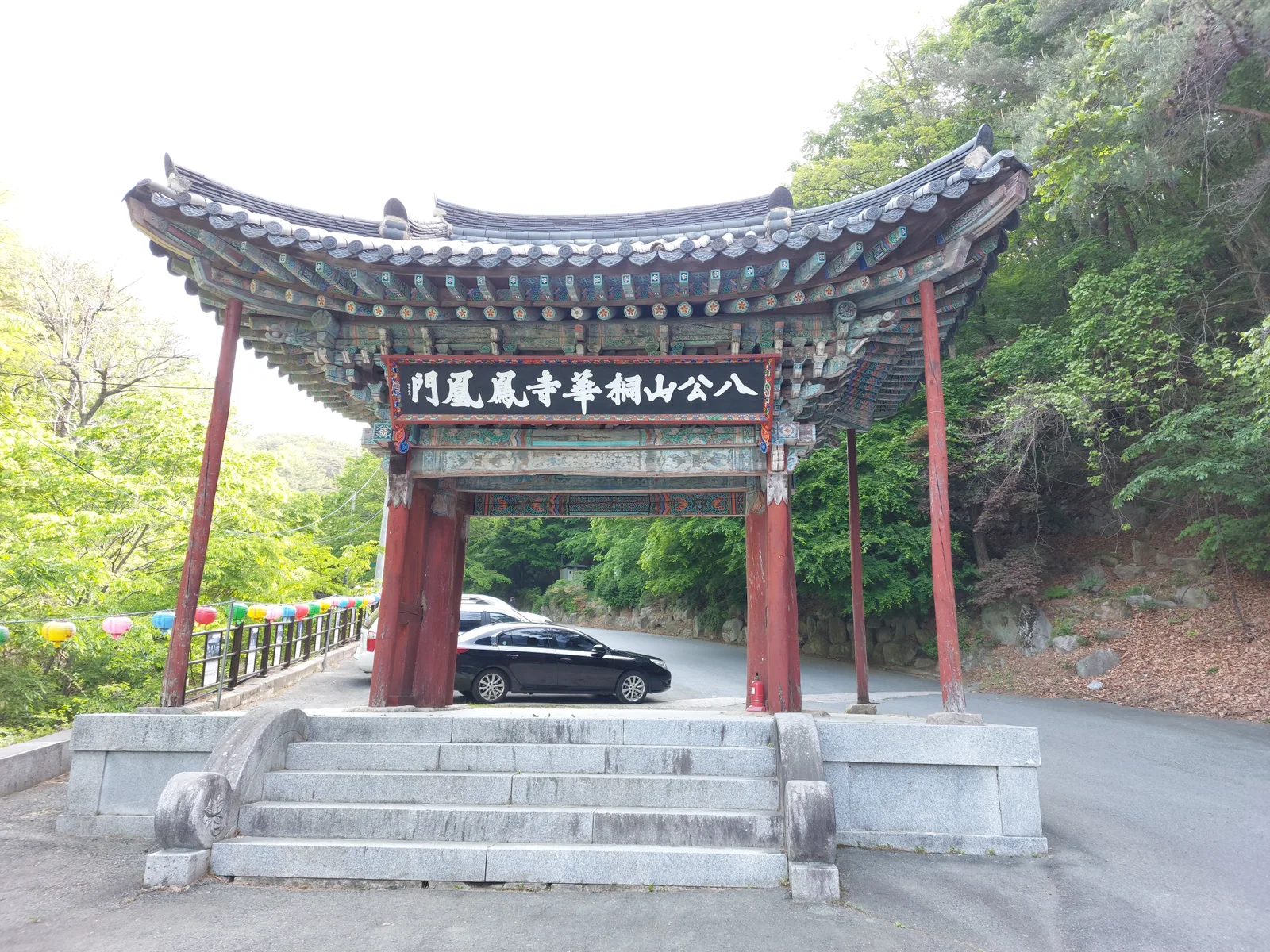 '팔공산 동화사 봉황문' 현판이 걸린 대구 팔공산 동화사 일주문, 처마 아래로 자동차가 통과하고 있다
