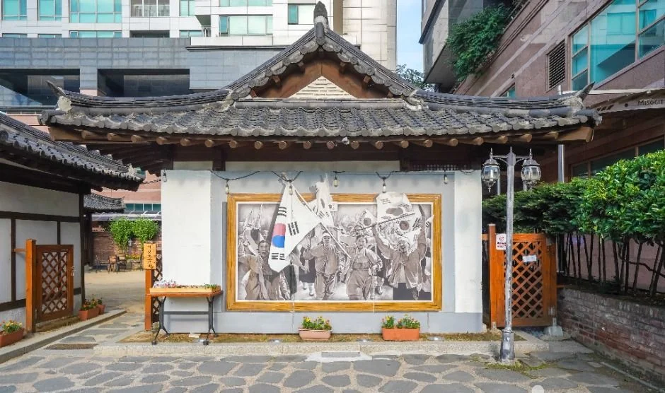 한옥 지붕 아래 사진 벽화가 설치된 서상돈 고택 출입부