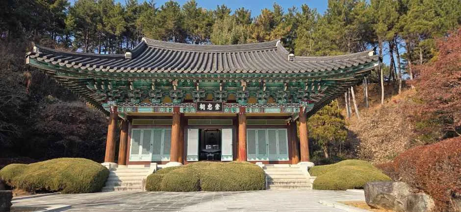 붉게 물든 나뭇잎이 보이는 기와지붕 전각 건물