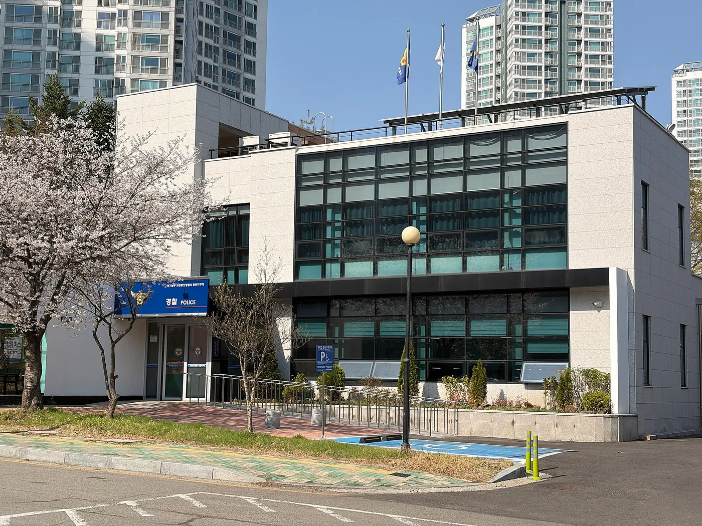 경찰 지구대 건물 앞 도로변에 파란색으로 칠한 장애인 주차면이 있는 모습