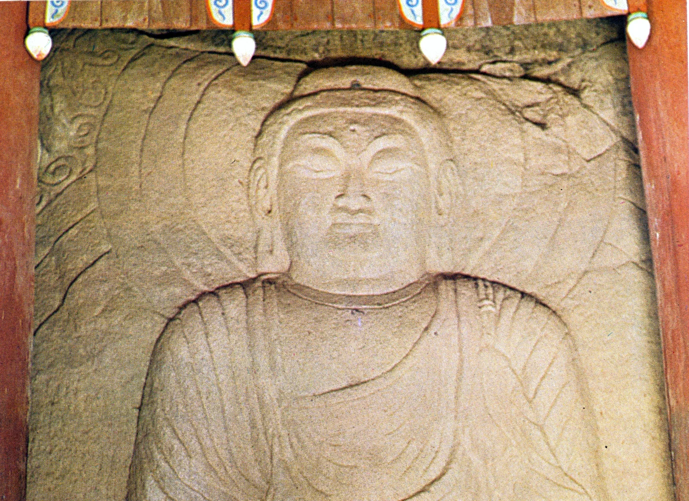 바위 면에 새겨진 마애여래좌상의 얼굴과 상반신이 보이는 사진