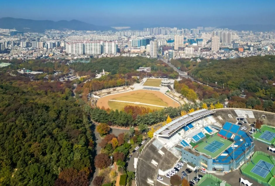 단풍이 든 숲에 둘러싸인 두류공원의 경기장과 테니스 코트를 위에서 본 모습