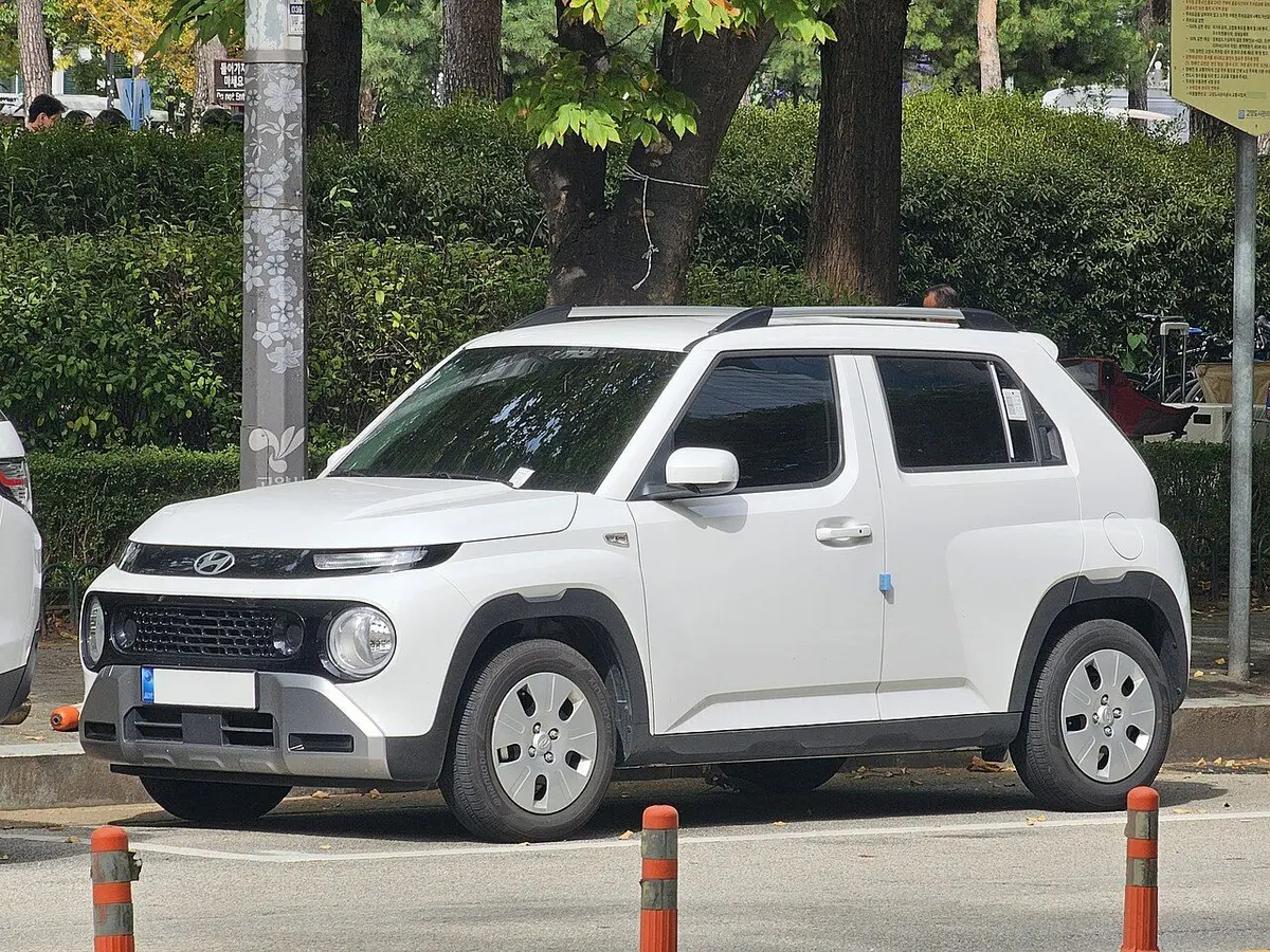 흰색 현대 캐스퍼의 전측면, 철제 휠 커버와 루프 레일이 보인다