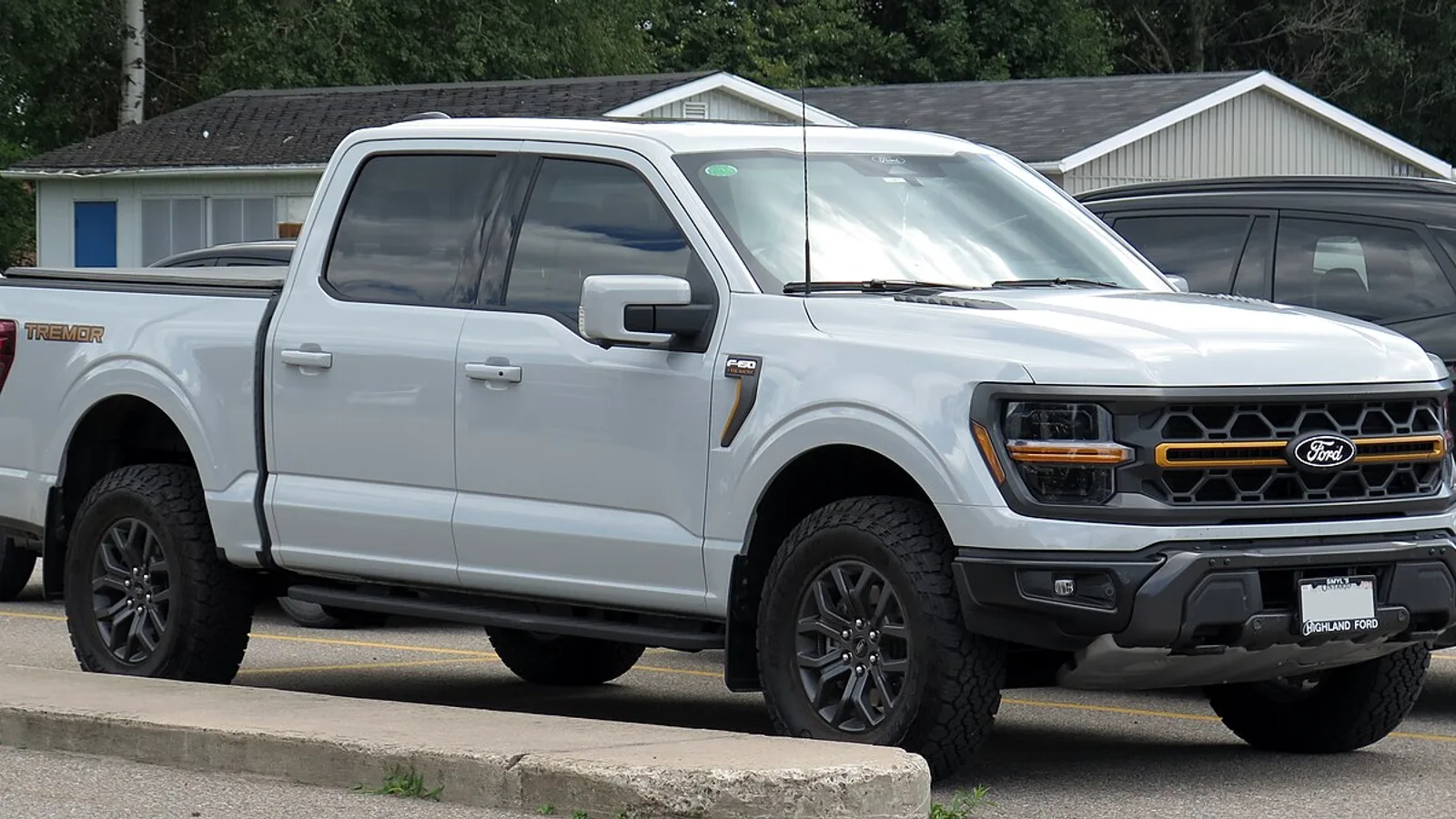흰색 포드 F-150 트레모어 슈퍼크루의 전측면 모습, 적재함과 프레임 하단부가 함께 보인다