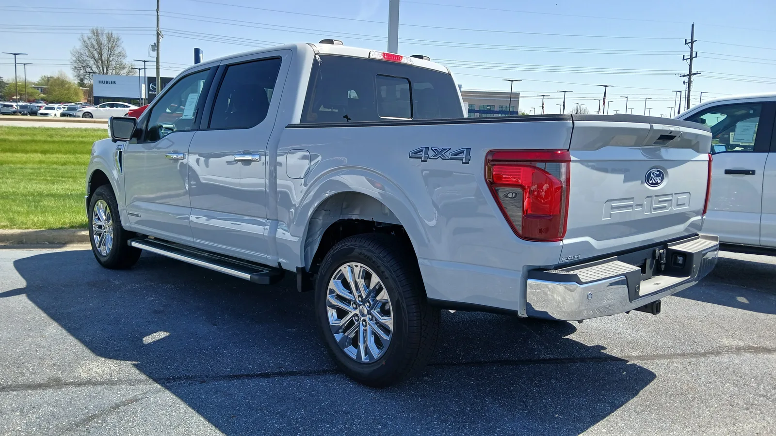 흰색 포드 F-150 XLT 슈퍼크루의 후면부, 테일게이트와 리어 콤비네이션 램프가 보인다