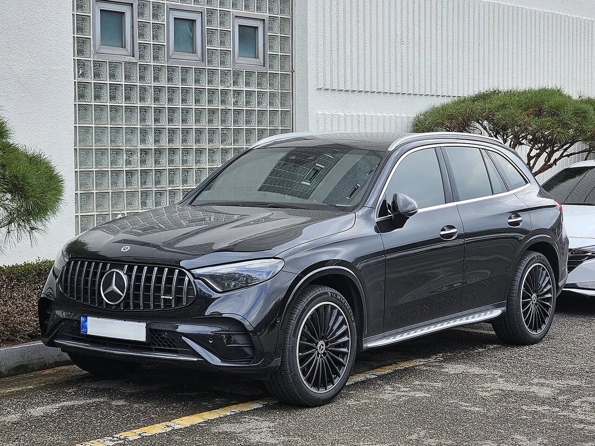 검은색 메르세데스-벤츠 GLC 300 4MATIC AMG 라인의 전측면, 주차 구역에 세워져 있다