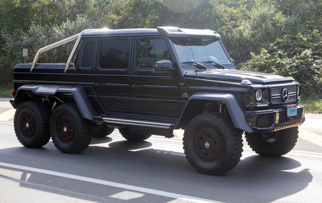 검은색 메르세데스-벤츠 G63 AMG 6x6의 측면 모습, 뒤쪽 두 쌍의 바퀴와 확장된 펜더가 보인다