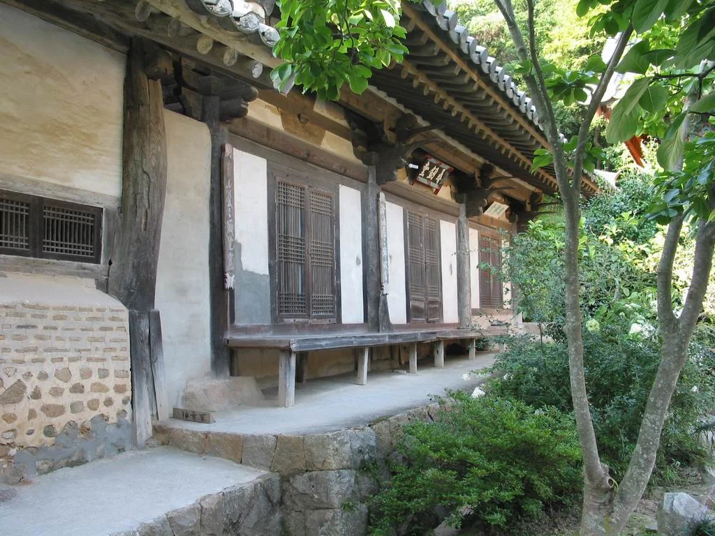 나무와 돌계단 옆에 선 개심사 심검당 외벽