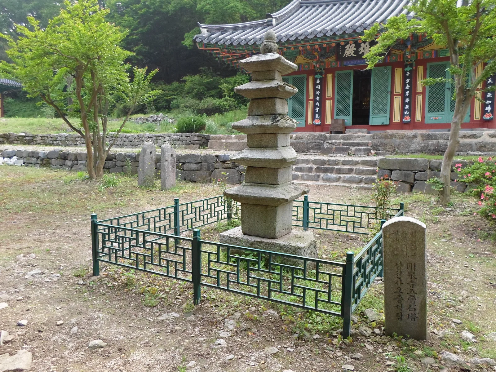 강천사 대웅전 앞에 서 있는 화강암 오층석탑, 녹색 철제 울타리로 둘러싸여 있다