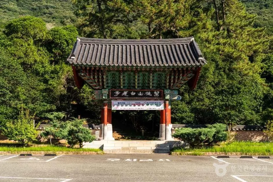 기와지붕을 얹은 사찰 입구 문과 앞 주차 공간