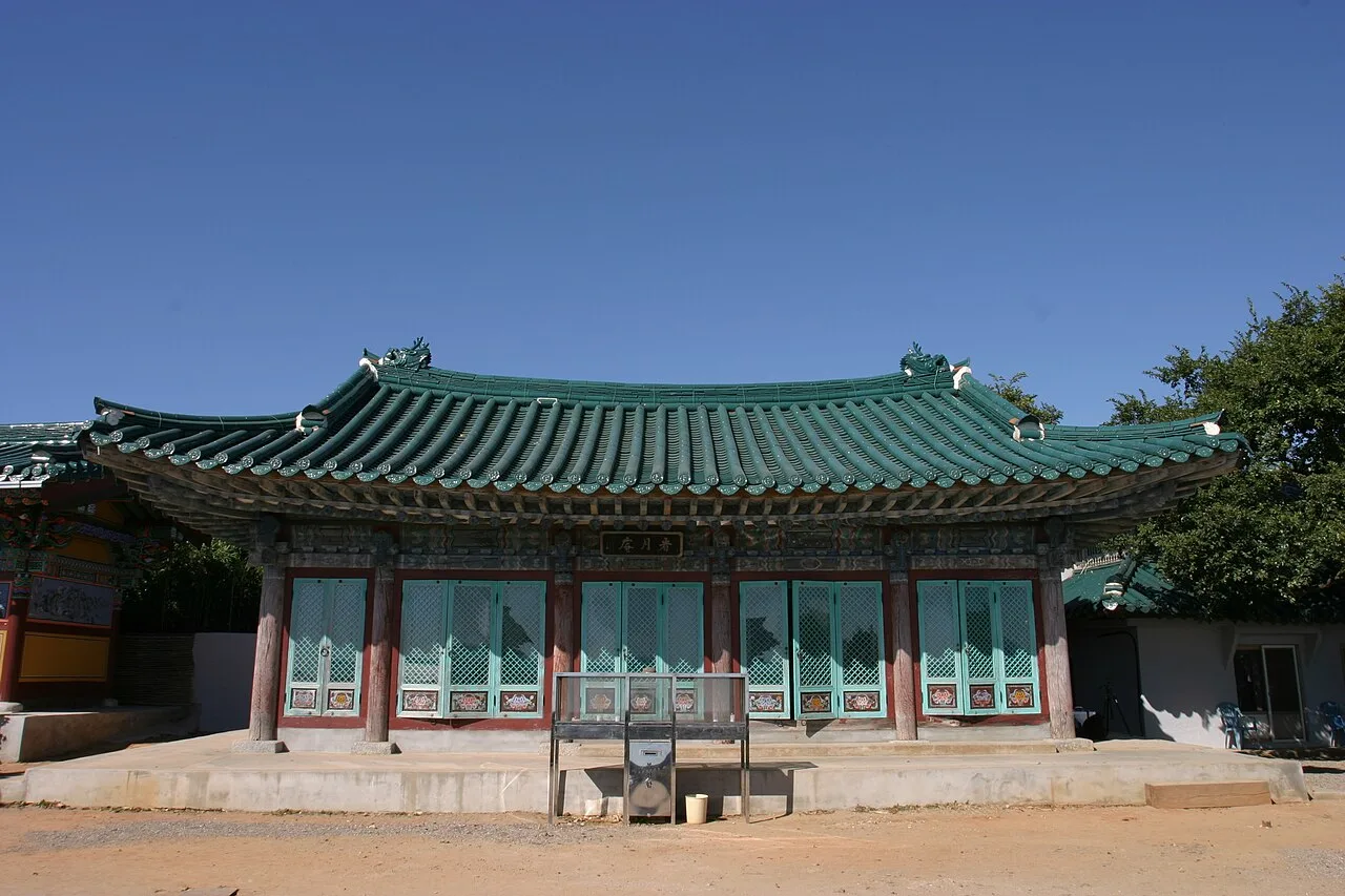 간월암 경내에 자리한 전각, 처마 밑에 현판이 걸려 있고 맑은 하늘이 배경으로 보인다