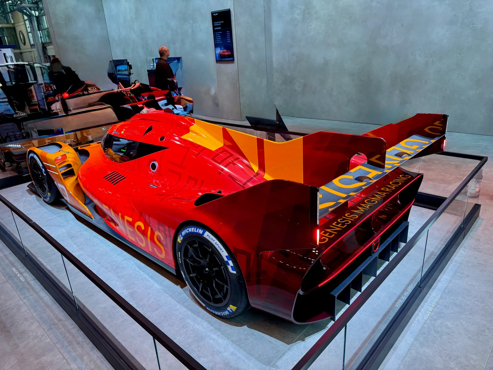 전시장에 세워진 제네시스 GMR-001 하이퍼카의 후면 모습, 대형 리어윙과 GENESIS MAGMA RACING 레터링이 보인다