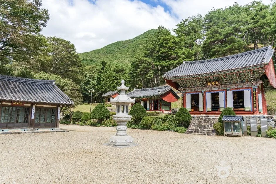 산을 배경으로 한 보석사 대웅전과 석등, 자갈이 깔린 경내 마당