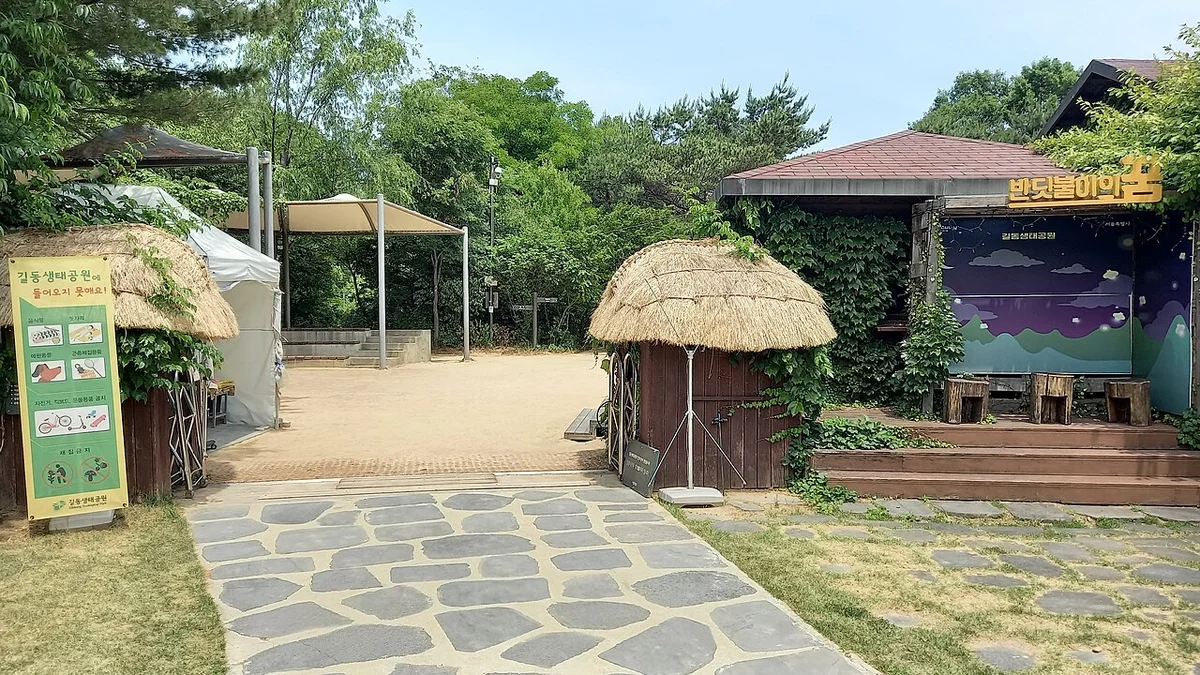 초가지붕 움집과 돌길이 보이는 공원 광장