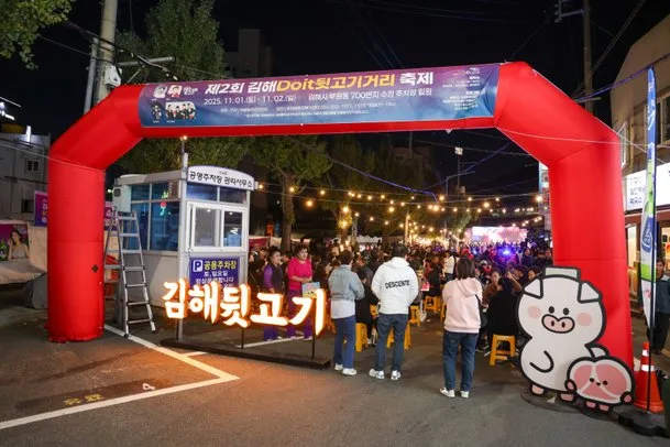 빨간색 풍선 아치 조형물에 '김해뒷고기'라고 적혀 있고 그 옆으로 매표소 건물이 있는 축제 입구 모습