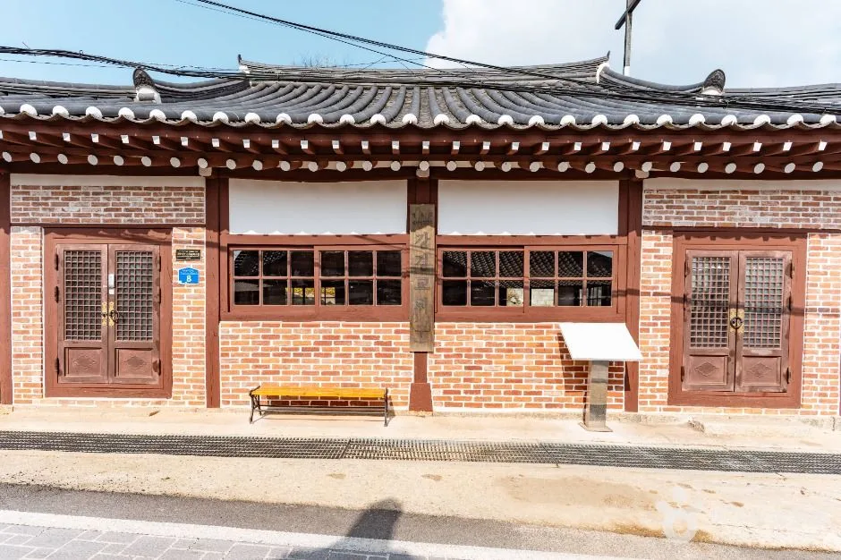 붉은 벽돌 벽과 한옥 기와지붕, 격자 창이 어우러진 한옥형 예배당 건물 정면